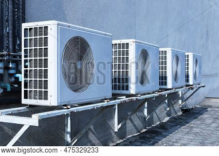 Air Compressor On The Side Of The Wall. Row Of Antique White Condensers Or Air Conditioners Mounted 