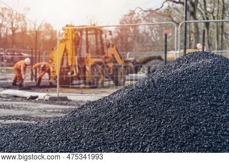 Asphalt Paver Filled With Hot Tarmac Laying New Road Surface On New Residential Housing Development 