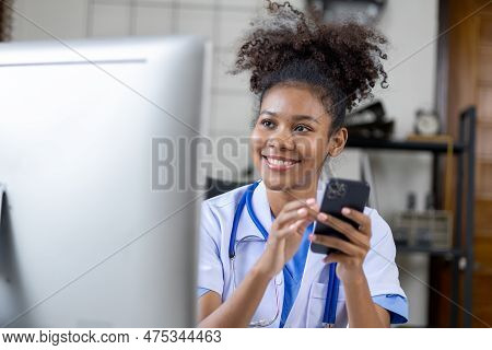 An American Female Doctor Is Using A Mobile Phone, She Is A General Practitioner And Internal Medici