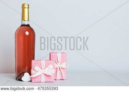 Bottle Of Wine On Colored Background For Valentine Day With Gift Box. Heart Shaped With Presrnt Box 