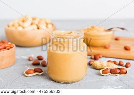 Bowl Of Peanut Butter And Peanuts On Table Background. Top View With Copy Space. Creamy Peanut Pasta