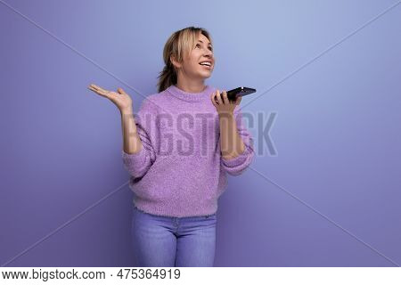 Smiling Blond Young Woman Chatting In Surprise Using Smartphone On Bright Colorful Background