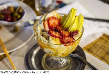 A Glass Of Morocco Fruit Salad Mixed With Sliced Strawberries, Apples And Banana Placed On Local Res