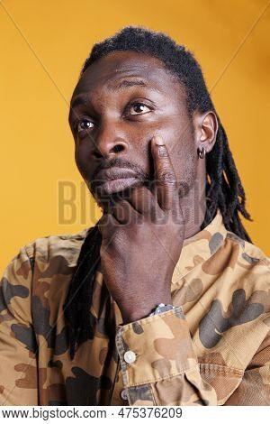 Thoughtful Man Thinking At Business Ideas In Studio Over Yellow Background, Feeling Confused And Won