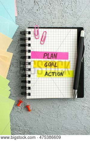Vertical View Of Plan Goal Action Writings On Spiral Notebook On Black Book And Coloured Envelopes O