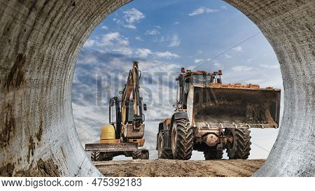 Powerful Wheel Loader Or Bulldozer Working And Mini Excavator Against Blue Cloudy Sky. Modern Equipm