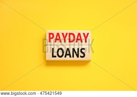 Payday Loans Symbol. Concept Words Payday Loans On Beautiful Wooden Block. Beautiful Yellow Table Ye