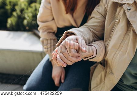 Two People Holding Hand Together Over Blurred Background. Giving A Helping Hand. Closeup Of An Elder