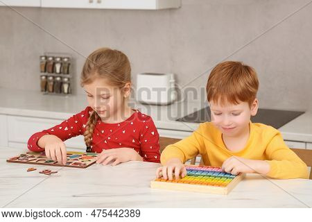 Children Playing With Different Math Game Kits At White Marble Table In Kitchen. Study Mathematics W
