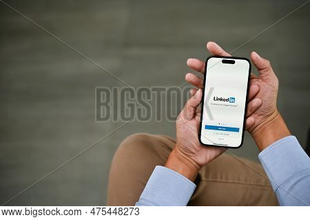 A Man Using Linkedin On His Iphone. Linkedin Logo On Iphone Screen Mockup