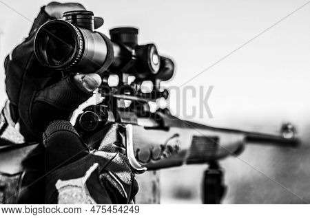 Shooter Sighting In The Target. Hunter With Hunting Gun And Hunting Form To Hunt. Hunter Is Aiming. 
