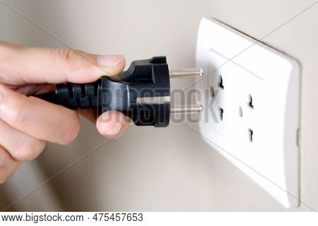 Hand Of Electrical Appliances He Was Pulling The Plug. Out Of The Plug. In His Office During Work Ho