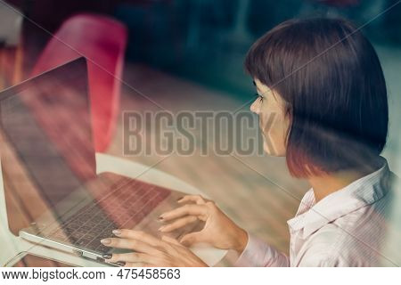 Concentrated Young Girl Working Remotely In Coffee Shop. It Highlights The Flexibility And Convenien