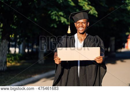 Portrait Of Happy Black Guy Standing With Empty Cardboard Poster On Street Looking For Job, Free Cop