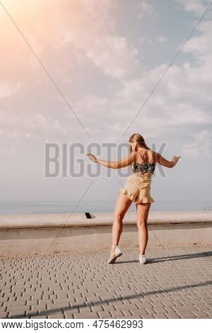 Woman Summer Dance. Silhouette Of A Happy Woman Who Dances, Spins And Raises Her Hands To The Sky. A