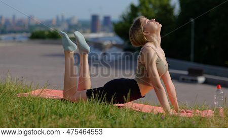 Caucasian Beautiful Female Practicing Yoga In Nature Using Gym Mat. Fit Woman Exercising. Positive Y