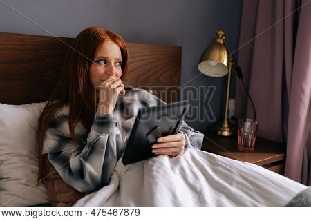 Closeup Of Grief-stricken Young Woman Lying On Bed Under Blanket Holding Photo In Frame And Crying L