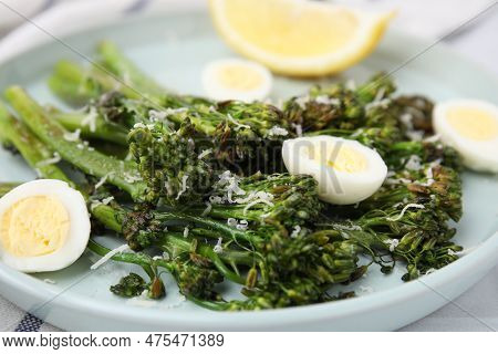 Tasty Cooked Broccolini With Cheese And Quail Eggs On Plate, Closeup