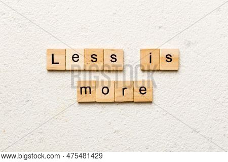 Less Is More Word Written On Wood Block. Less Is More Text On Table, Concept.