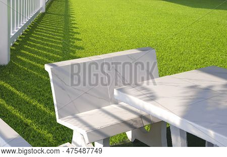 White Outdoor Marble Table Set On Green Artificial Turf And White Wooden Picket In Front Yard Area A