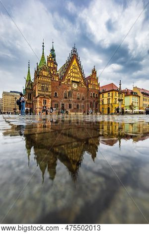 Wroclaw, Poland - July 2022: Wroclaw Market Square Old Tenement Houses Reflected In Small Puddle