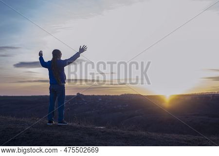 A Girl With Raised Hands On The Background Of The Sky. Prayer. Glorification Of God. Worshiping Jesu