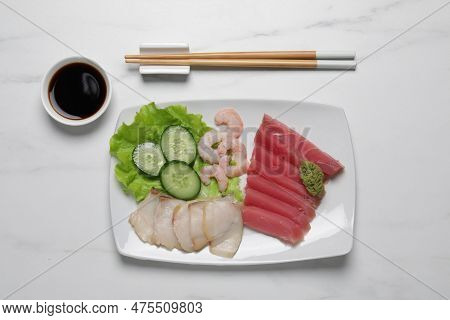 Sashimi Set (raw Slices Of Tuna, Oily Fish And Shrimps) Served With Cucumber, Lettuce, Vasabi And So