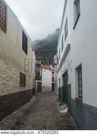 Narrow Cobbled Street With Traditional White Houses In The Village Of Agulo Located In Green Valley 