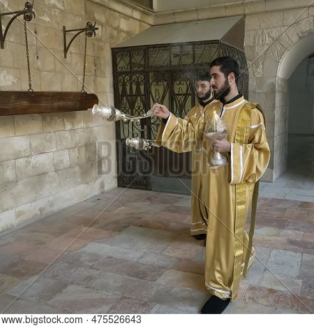 Jerusalem, Israel - November 12th, 2022: Armenian Priests Swinging Incense Thuribles Outside The St.
