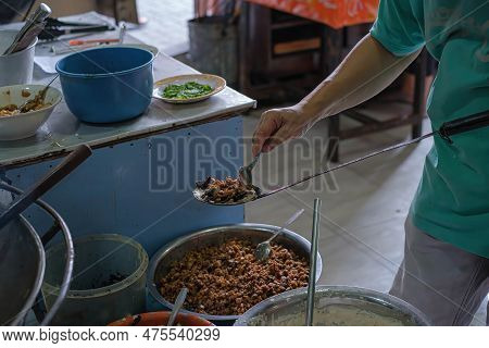 A Man Pouring Pork Meats Into A Spatula To Be Fried To Make Indonesian Vegetable Fritter Or Ote-ote 