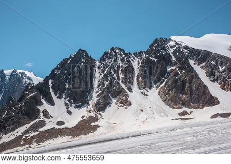 Scenic Mountain Landscape With Glacier Under Sharp Rocks In Sunlight. Awesome Alpine Landscape With 