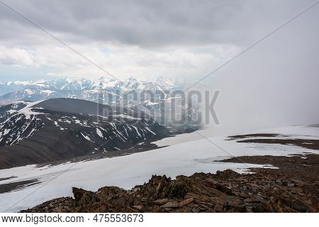 Awesome Top View Through Clouds To High Snowy Mountains. Scenic Landscape With Beautiful Snow Mounta
