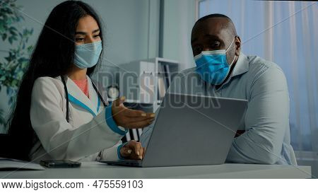 Young Doctor Woman Talk With Old Man Patient In Mask Use Laptop Check Electronic Health Test Result 