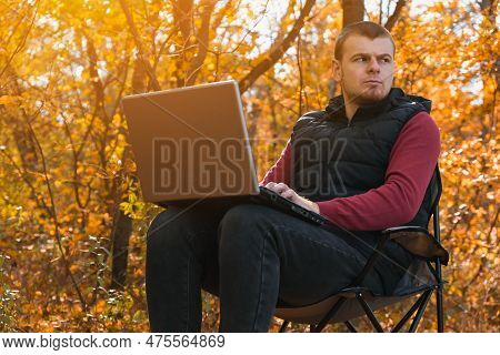 A Freelance Man Works Remotely In Nature In The Autumn Forest. Country Life. A Break From Civilizati