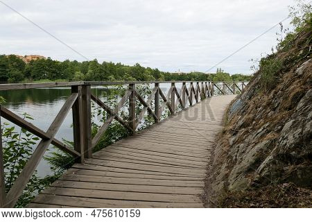 Empty Footpath Amidst Next To Lake Against Sky