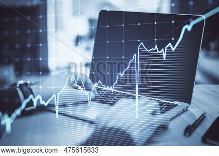 Close Up Of Businessman Hands Using Laptop Kyeboard With Growing Blue Financial Forex Chart On Blurr