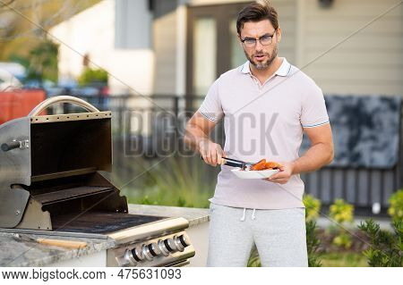 Man At A Barbecue Grill. Male Cook Preparing Barbecue Outdoors. Bbq Salmon Fillet, Grill For Picnic.