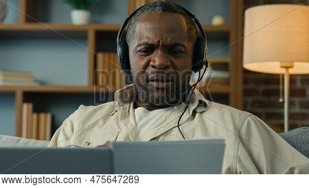 Mature African American Man In Headphones Remote Discuss With Partner At Online Conference Use Lapto