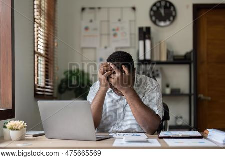 Unhappy Hopeless African American Man Holding Head In Hands, Overwhelmed Tired Businessman Sitting A