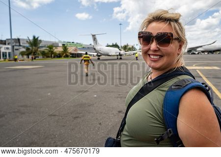 Happy Smiling Woman On The Tarmac Of The Zanzibar Airport In Tanzania, Just After Landing