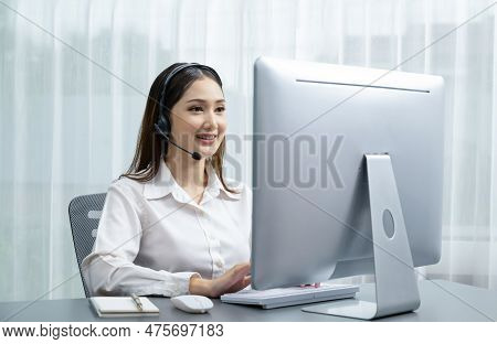 Asian Call Center With Headset And Microphone Working On Her Laptop. Female Operator Provide Excepti