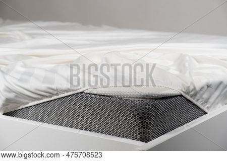 White Satin Sheet On An Elastic Band On The Mattress. Bed Linen On The Bed