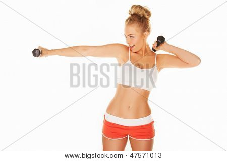 Güzel genç kadın kolu uzanan dumbbells ile egzersiz düzgün bir atletik rakam ile uygun
