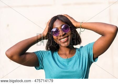 Sunkissed Summer Vibes: Portrait Of A Black Tourist Woman In Green Tee And Sunglasses