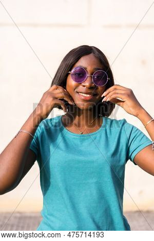 Sunkissed Summer Vibes: Portrait Of A Black Tourist Woman In Green Tee And Sunglasses