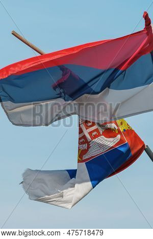 Torn And Weathered Flag Of Serbia On A Post Waving In Wind, Selective Focus