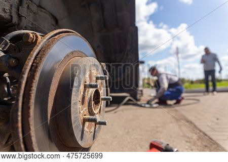 Car On Tire Mounting With Removed Wheel On Pneumatic Jack, Seasonal Tire Change, Car Service Concept