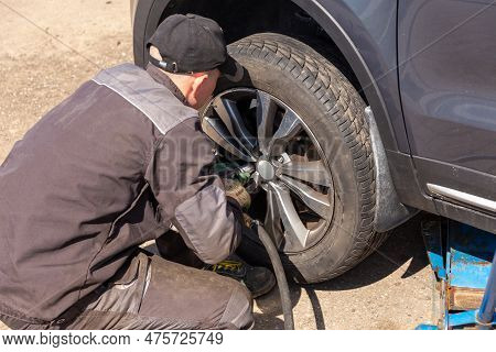 Mechanician Changing Car Wheel In Auto Repair Shop.