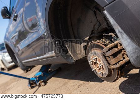 Car On Tire Mounting With Removed Wheel On Pneumatic Jack, Seasonal Tire Change, Car Service Concept