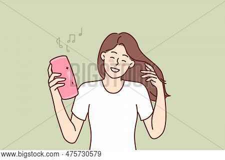 Woman With Wireless Portable Speaker Smiling Enjoying Loud Rhythmic Music Of Favorite Rock Band. You